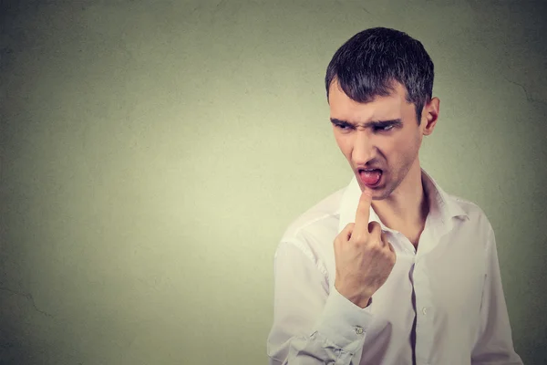 Disgusted man with finger in mouth displeased ready to throw up — Stock Photo, Image