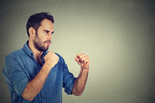 Angry young man clenching his fists — Stock Photo, Image