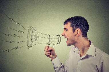 Side profile business man shouting into a megaphone isolated on gray background 