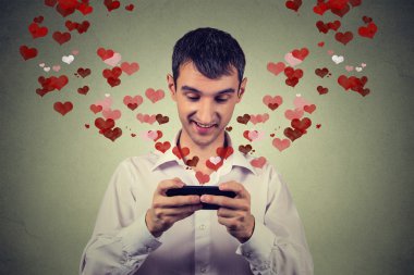 handsome happy man sending receiving love sms text message on mobile phone