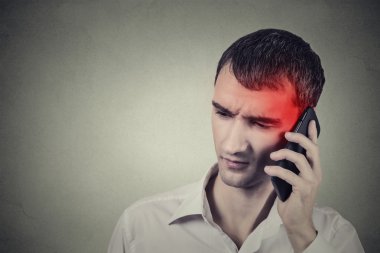Man on the phone with headache. Cellular mobile radiation concept