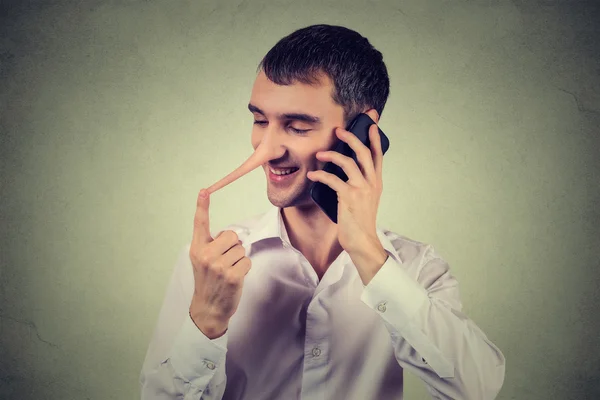 Liar customer service representative. Happy man with long nose talking on mobile phone — Stock Photo, Image
