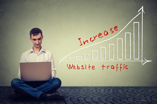Mann mit Laptop arbeitet an einem Plan zur Erhöhung des Webseiten-Traffics. Technologie-Marketing-Konzept — Stockfoto