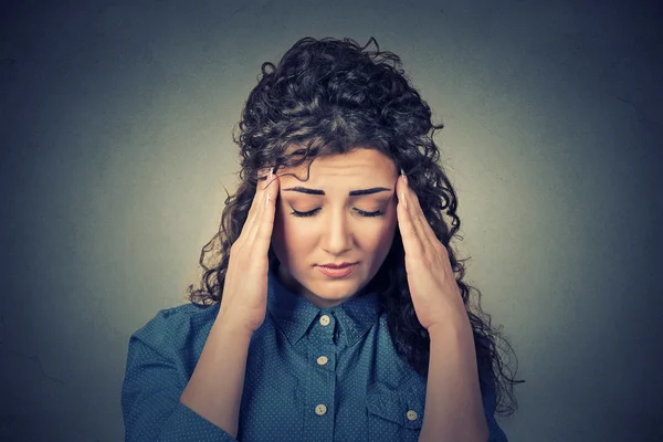 Triest jonge vrouw met bezorgd benadrukt gezicht expressie met hoofdpijn — Stockfoto