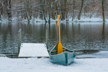 Huron River, Michigan 'daki ilk kar. Rıhtıma taze karla kaplı yeşil bir kano ve kürek bırakılmıştı..