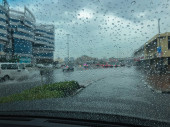 Dunkle Wolken, die über Dubai ziehen und heftige Regenfälle, die die Straßen überfluten und es Autofahrern und Autofahrern schwer machen.