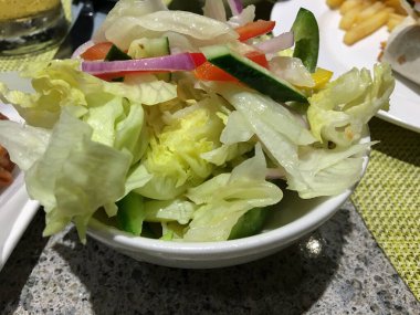 Masada duran bir kase sağlıklı ve taze kesilmiş sebze salatası..