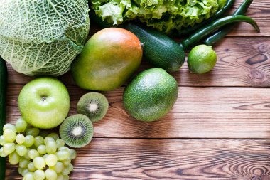 Taze çiğ meyve ve sebzeler tahta masanın üzerinde düz kompozisyonda yatıyordu. Besleyici sağlıklı lezzetli lezzetli vejetaryen vejetaryen diyet konsepti.
