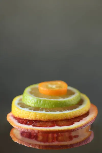 Olgun taze Sicilya kanı portakallı limonlu limonlu kumkuat, koyu yeşil arka plan. Sulu, tatlı, ekşi, narenciye, ince dilimlenmiş yığın. Sağlıklı besleyici gıda konsepti, vejetaryen vejetaryen diyeti