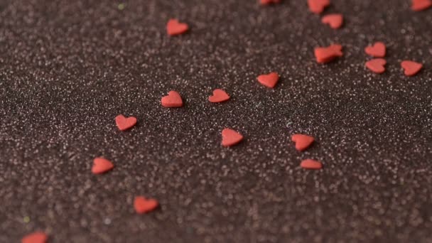 赤い緋色のハート形の砂糖菓子の作品は より多くの秋のカバー散乱茶色の光沢のある表面遅い動きをカバーしています ロマンチックな愛 バレンタインデー 母の日 結婚式の準備デザインコンセプト — ストック動画