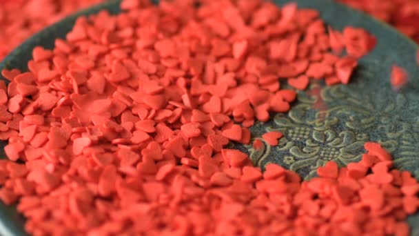 Corazón Rojo Escarlata Forma Confeti Azúcar Desmoronándose Cayendo Plato Verde — Vídeo de stock