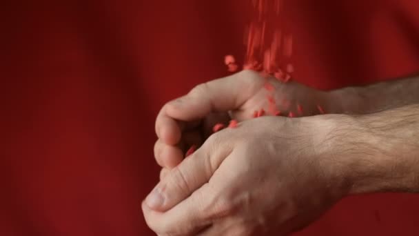 Red Scarlet Heart Shaped Sugar Confetti Crumbling Falling Men Hands — Stock Video