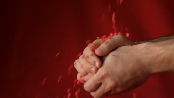 红红的红心形状的糖圆饼碎了 落在男人手中的红色背景 浪漫的爱情 圣瓦伦丁节准备设计理念 — 图库视频影像