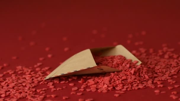 赤いハート型のシュガーコンフェッティは 赤い背景スローモーションでバレンタイングリーティングカードに落ちます ロマンチックな愛 愛情バレンタインデー 母の日 結婚式の準備デザインコンセプト — ストック動画