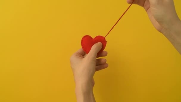 Mão Menina Jovem Costura Coração Feltro Vermelho Fundo Amarelo Amor — Vídeo de Stock