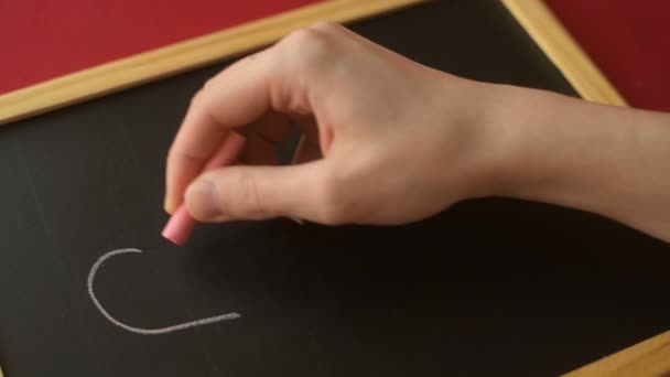 女孩或年轻女子的手用粉笔在黑板上勾画出心形 浪漫的爱情 爱心的情人节 母亲节 婚纱设计理念 — 图库视频影像