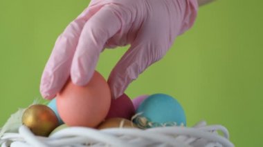 Pembe, altın ve yeşil renkte renkli Paskalya yumurtaları pembe ve mor sümbül çiçekleriyle bulanık yeşil arka planda dönen samanların üzerinde yatar. Bahar Hıristiyan bayramı tasarım konsepti