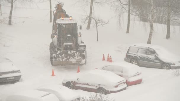 Tractor Schoonmaken Van Straten Tussen Huizen Van Sneeuw Tijdens Sneeuwval — Stockvideo