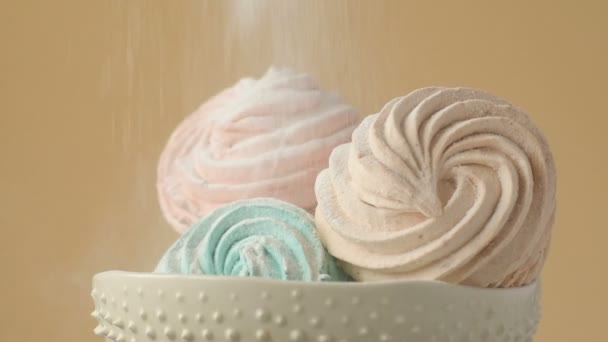 柔和的薄荷绿色 粉色和奶油色的甜彩色自制棉花糖在陶瓷盘上缓慢旋转 黄色背景上撒满糖粉 家庭烹饪 — 图库视频影像