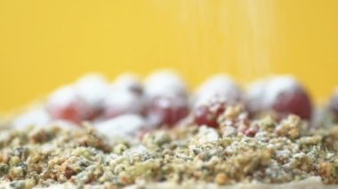 Ispanaklı ev yapımı vejetaryen pastası yavaşça dönen kızılcıkla süslenmiş ve yavaş çekimde sarı zemine şeker tozu serpiştirilmiş. Sağlıklı vejetaryen ve ev yapımı gıda konsepti
