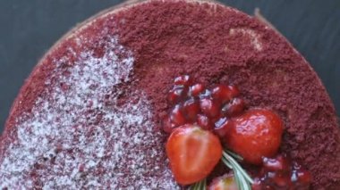 Marsala çikolatalı mus keki, nar, çilek, biberiye ve şeker tozuyla süslenmiş, yavaşça dönüyor. Güzel desenli pasta, üst manzara, makroyu kapat.. 