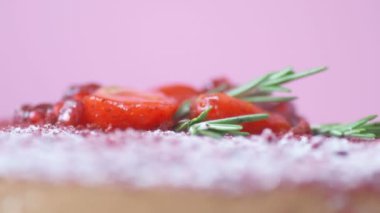 Nar, çilek, biberiye ve şeker tozuyla süslenmiş Marsala çikolatalı kremalı pasta. Güzel desenli pasta, üst manzara, makroyu kapat. Güzel dokuma pastası, yan manzara. Ev yapımı tatlılar
