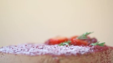 Nar, çilek, biberiye ve şeker tozu ile süslenmiş Marsala çikolatalı mus keki kahverengi arka planda döner. Güzel desenli pasta, üst manzara, makroyu kapat. Tatlı konsepti