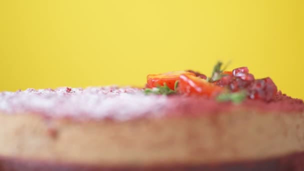 ザクロ イチゴ ローズマリー 砂糖の粉で飾られたマルサラチョコレートムースケーキは 黄色の背景に回転します 美しい食感ケーキ トップビューをマクロを閉じます デザートコンセプト — ストック動画