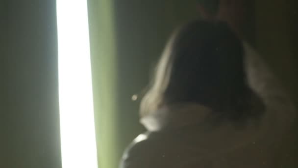 Beyaz Gömlekli Bir Kadın Tozlu Bir Odanın Penceresine Doğru Yürür — Stok video