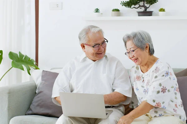 Asian Senior Couple Using Computer Laptop Internet Searching Online Shopping Stock Photo