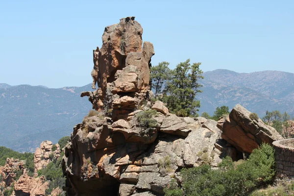 Mavi gökyüzünde kocaman delikleri olan kayalar.