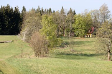 Bir ev ve ormanla dağlarda bahar manzarası