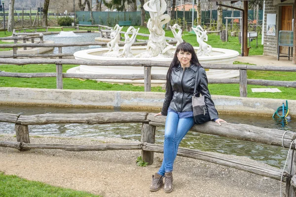 Meisje zitten op houten hek — Stockfoto