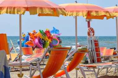 İtalyan sahilinde renkli şezlong, şemsiye ve oyuncaklar