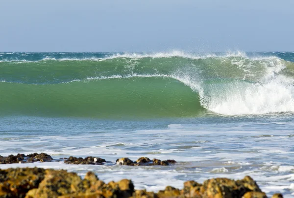 Rompiendo olas cerca de algunas rocas —  Fotos de Stock