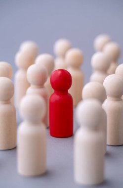Tahtadan yapılmış kırmızı bir adam figürü, kalabalığın arasında duruyor. Farklı insanlar. Işıklar arasında eşsiz bir insan şekli. Liderlik, bireysellik ve kalabalığın dışında kalmak.