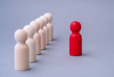 Liderlik kavramı, tahtadan yapılmış kırmızı bir adam figürü, kalabalığın arasında öne çıkıyor. Farklı insanlar. Yeni fırsatlara koşun. Yetenek yönetimi, işe alım çalışanı, iş ekibi lideri.