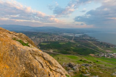 Galilee Denizi 'nin kuzey kısmının gün doğumu manzarası ve Arbel Dağı' ndan Migdal köyü. Kuzey İsrail