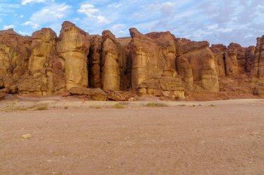 View of landscape and the Solomon Pillars rock formation, in the Timna Valley, Arava desert, southern Israel clipart