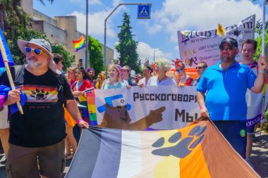 Hayfa, İsrail - 18 Haziran 2021: Hayfa, İsrail 'deki her yıl düzenlenen LGBTQ onur yürüyüşünde protesto işaretleri olan insanlar sokakta yürüyor. Post Covid-19 kutlamaları