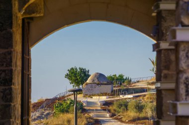 View of an old Ottoman era sheikh tomb, from the fortress, in Migdal Tsedek National Park, central Israel clipart