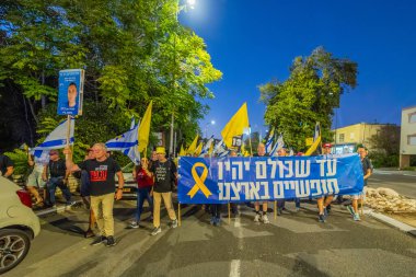 Hayfa, İsrail - 11 Ekim 2025: Çeşitli tabelaları ve bayrakları olan insanlar, savaşı sona erdirmek ve rehineleri serbest bırakmak için ateşkesi destekleyen bir protesto mitingine katıldılar. Hayfa, İsrail