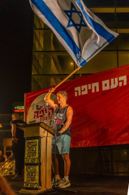 Hayfa, İsrail - 11 Ekim 2025: Çeşitli tabela ve bayraklı bir kalabalık, savaşı sona erdirmek ve rehineleri serbest bırakmak için ateşkesi destekleyen bir protesto mitingine katıldı. Hayfa, İsrail