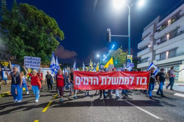 Hayfa, İsrail - 18 Ekim 2025: Çeşitli tabelaları ve bayrakları olan insanlar, ateşkes sonrasında hükümete karşı düzenlenen bir protesto mitingine katıldılar. Hayfa, İsrail