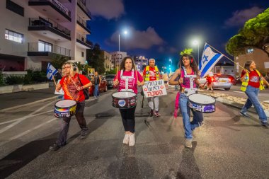 Hayfa, İsrail - 18 Ekim 2025: İnsanlar hükümete karşı yapılan ateşkesin ardından bir protesto yürüyüşüne (pembe grup) katılıyor. Hayfa, İsrail