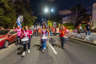 Hayfa, İsrail - 18 Ekim 2025: İnsanlar hükümete karşı yapılan ateşkesin ardından bir protesto yürüyüşüne (pembe grup) katılıyor. Hayfa, İsrail