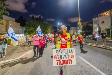 Hayfa, İsrail - 18 Ekim 2025: Çeşitli tabelaları ve bayrakları olan insanlar, ateşkes sonrasında hükümete karşı düzenlenen bir protesto mitingine katıldılar. Hayfa, İsrail