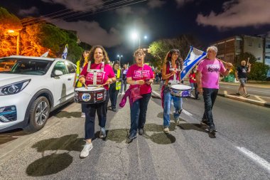 Hayfa, İsrail - 18 Ekim 2025: İnsanlar hükümete karşı yapılan ateşkesin ardından bir protesto yürüyüşüne (pembe grup) katılıyor. Hayfa, İsrail