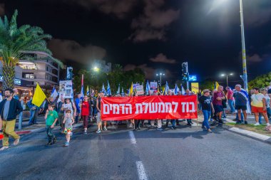 Hayfa, İsrail - 18 Ekim 2025: Çeşitli tabelaları ve bayrakları olan insanlar, ateşkes sonrasında hükümete karşı düzenlenen bir protesto mitingine katıldılar. Hayfa, İsrail