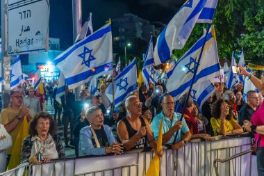 Hayfa, İsrail - 18 Ekim 2025: Çeşitli tabela ve bayraklara sahip bir grup insan, ateşkesin ardından hükümete karşı düzenlenen protestoya katıldı. Hayfa, İsrail